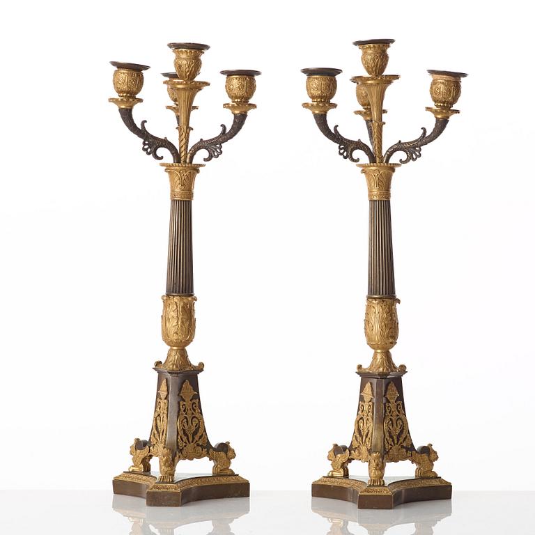 A pair of French Empire early 19th century gilt and patinated bronze four-light candelabra.