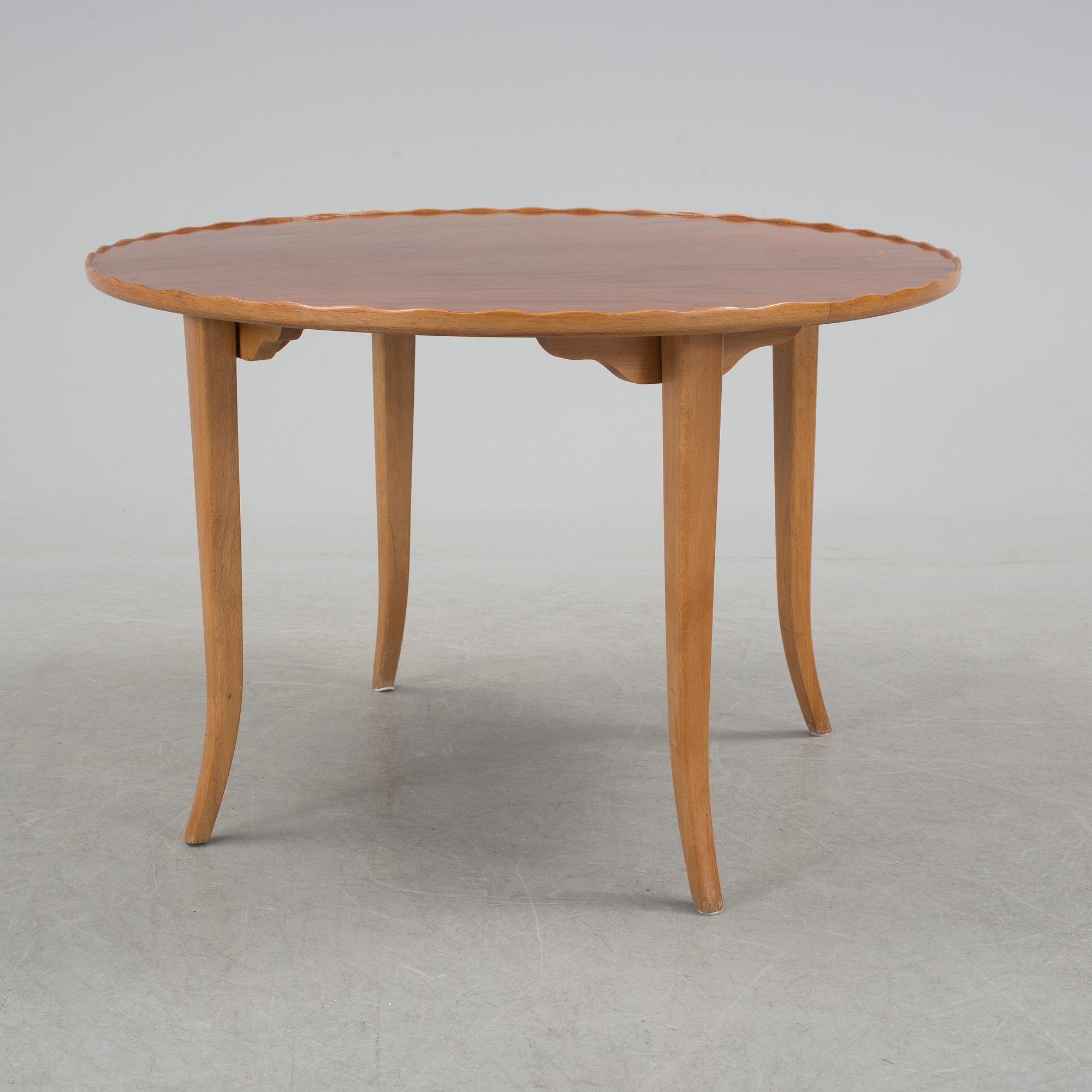 A mid 20th century coffee table in beech and veneered with mahogany.