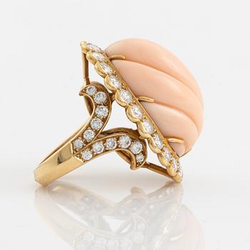 An 18K gold and coral Cartier ring set with round brilliant-cut diamonds.