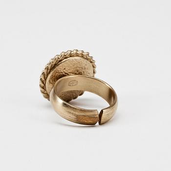 CHANEL, a gold colored logo ring.