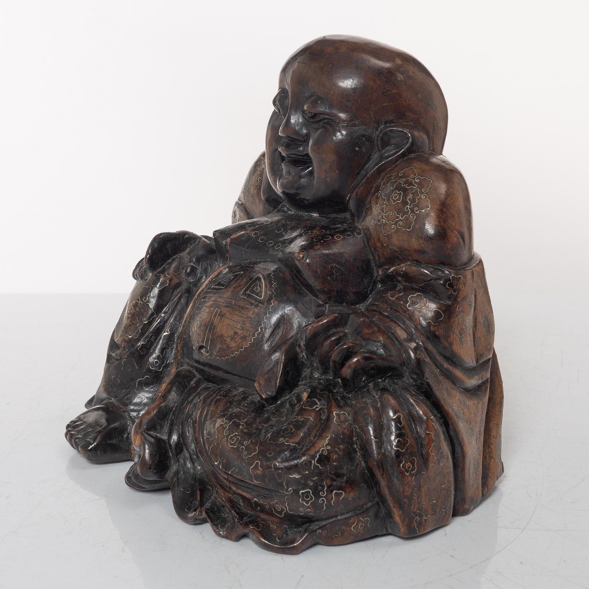 A Chinese wooden figure of Budai with silver inlays, Qing dynasty (1644-1912).