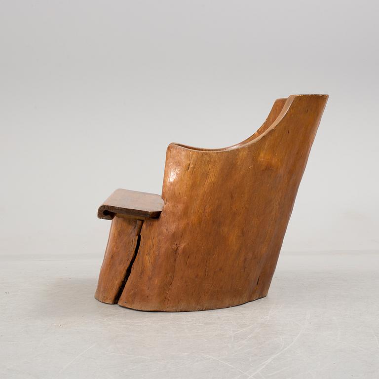 A tree trunk chair from the 20th century.