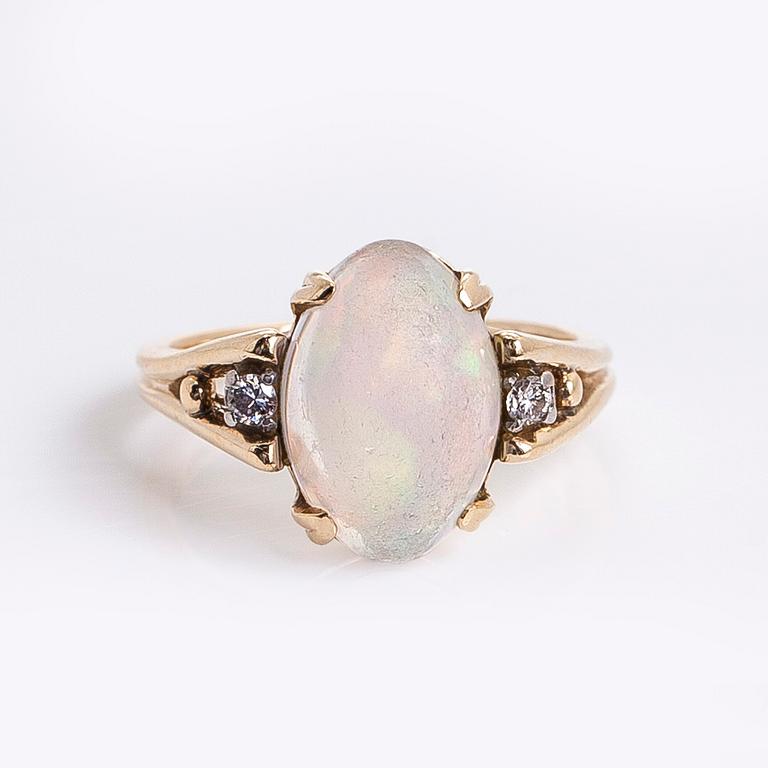 Ring in 14K gold with an oval opal and diamonds.