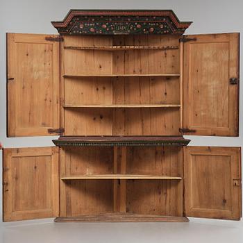 A Swedish polychrome painted folk art corner cabinet, dated 1818.