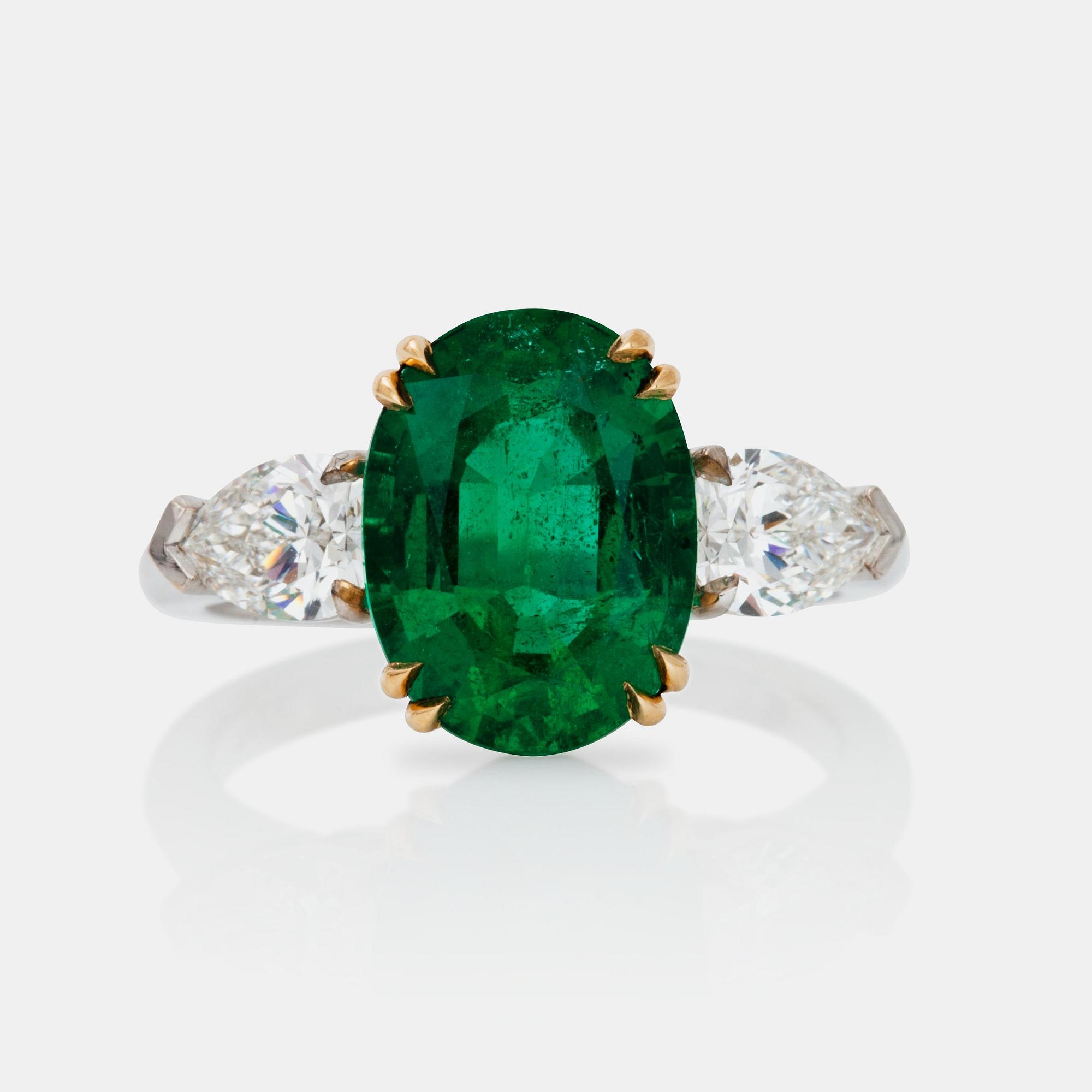 An emerald, circa 3.85 cts and diamond, circa 1.00 ct in total, ring.