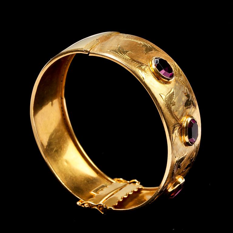 ARMBAND. 18k guld med tre ovalslipade lila stenar. 28g.