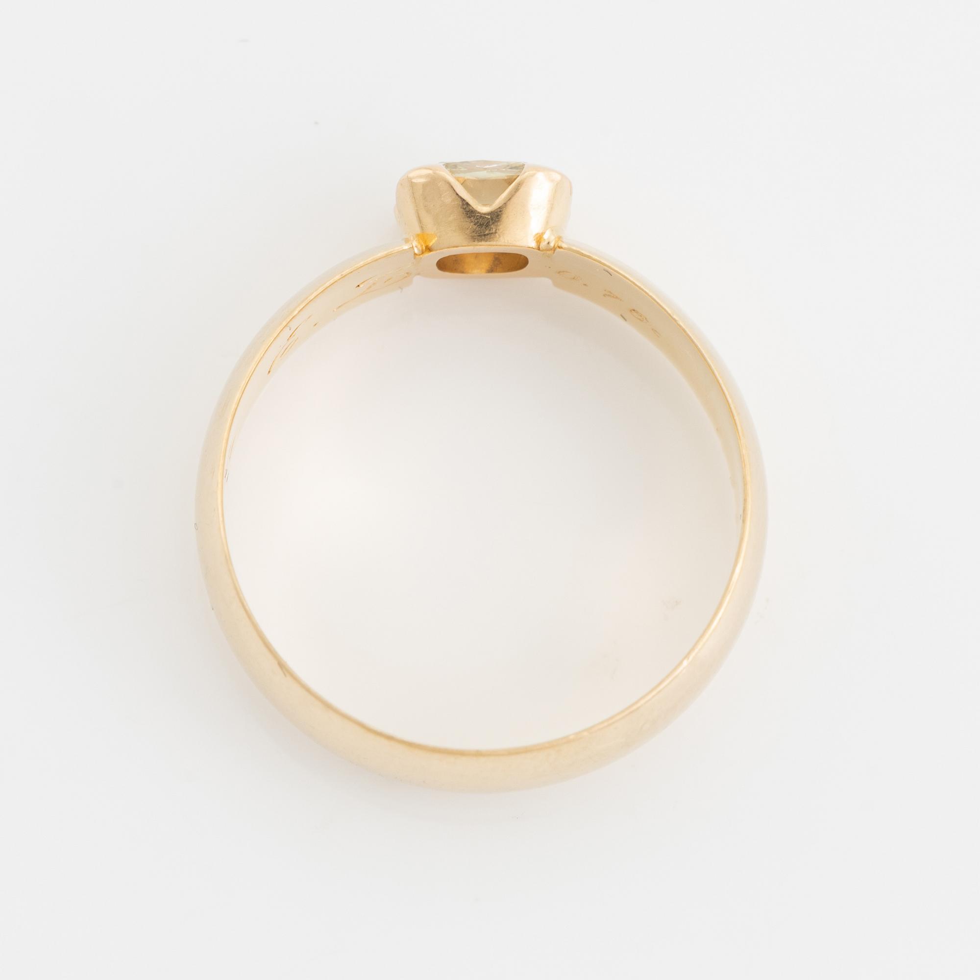 An 18K gold ring set with a radiant-cut diamond.