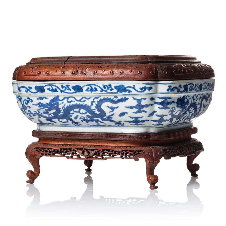 A blue and white quatrefoil dragon box with wooden cover and stand, Ming dynasty, Wanli mark and period (1573-1620).