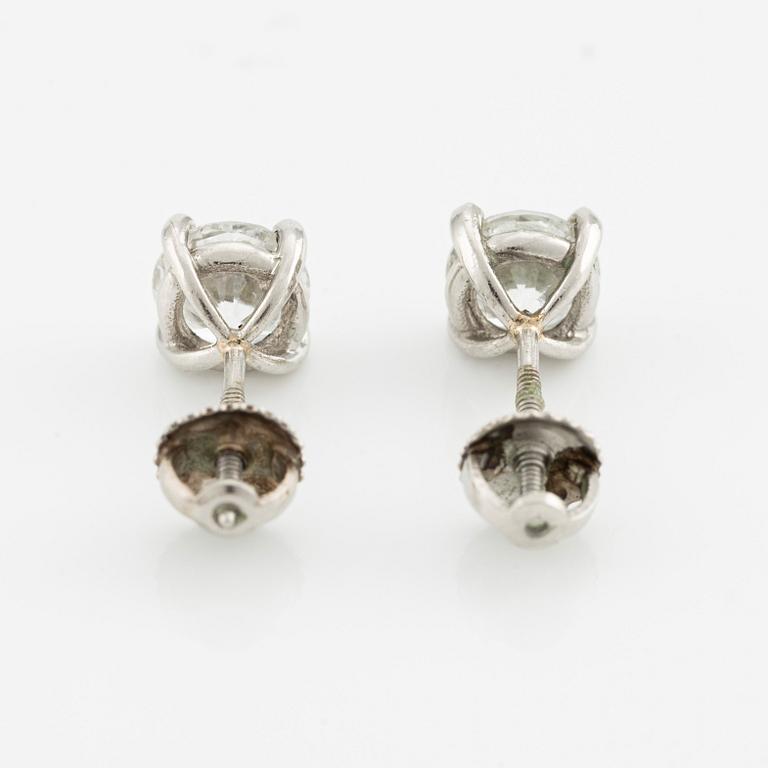 A pair of platinum earrings with round brilliant-cut diamonds.