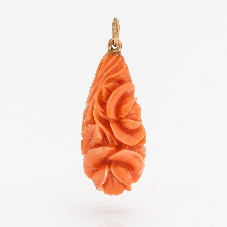 A pendant with carved coral and gold.
