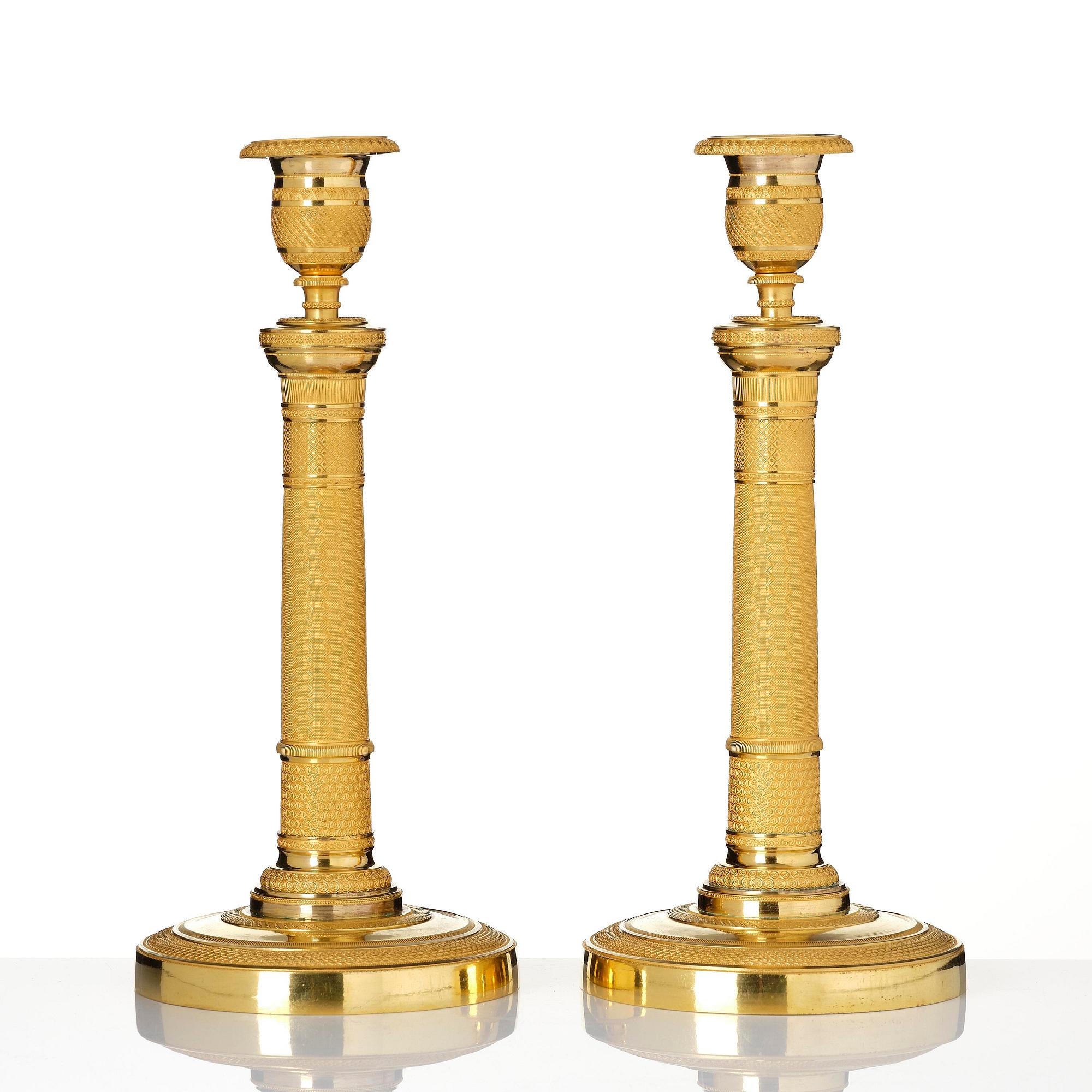A pair of French Empire gilt-bronze candlesticks, early 19th century.