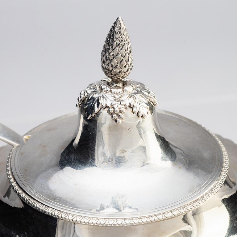 A Swedish Empire silver sugar bowl with lid and a suger sprinkle spoon, marks of Adolf Zethelius, Stockholm 1819.