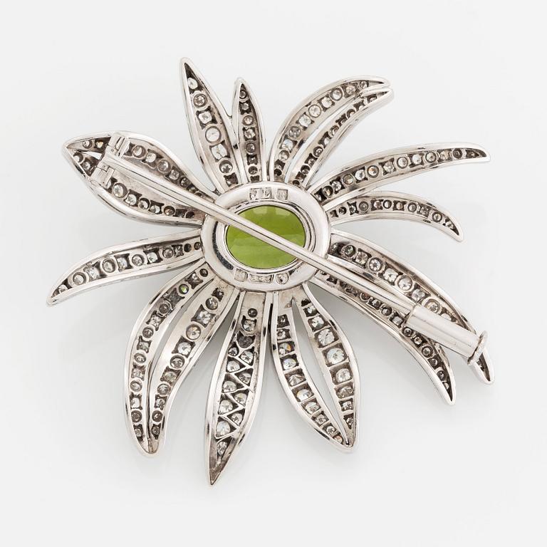 An 18K white gold brooch set with a faceted peridot and eight-cut diamonds.