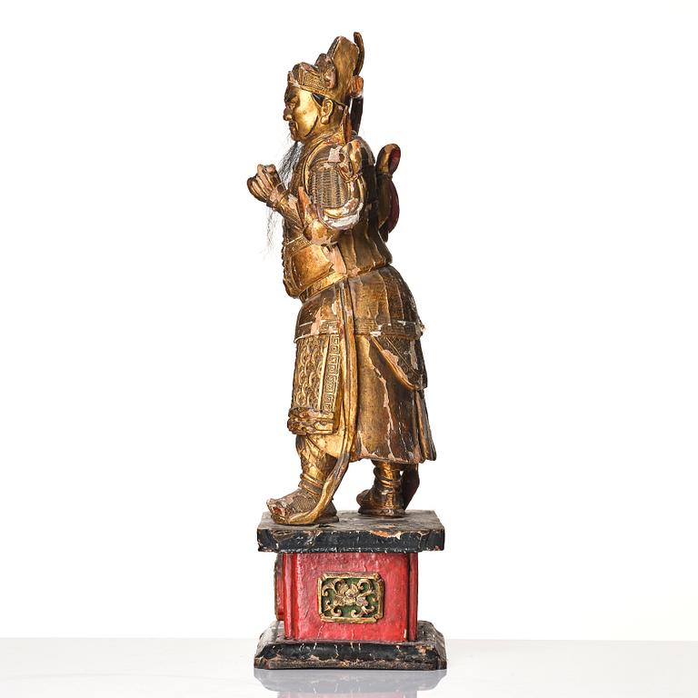 A gilt and lacquered standing figure of a guardsman, Qing dynasty.
