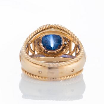 An 18K gold ring set with a cabochon-cut sapphire ca 4 cts and round brilliant- and eight-cut diamonds.