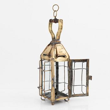 A metal storm lantern, marked A.T, circa 1900.