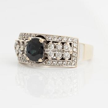 Ring with dark sapphire and brilliant-cut diamonds.