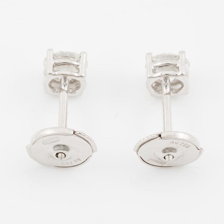 A pair of earrings in 18K white gold set with two round brilliant-cut diamonds.