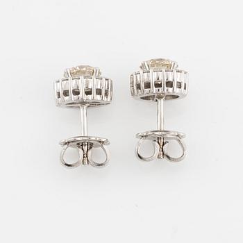 A pair of 18K gold earrings with round brilliant-cut diamonds.