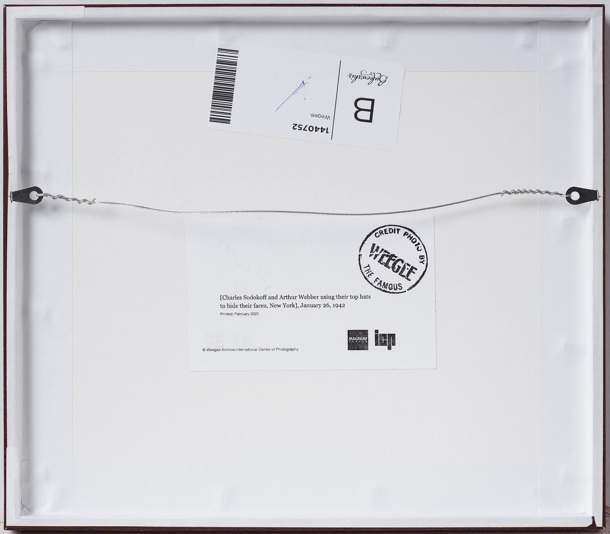 Weegee, "Charles Sodokoff and Arthur Webber using their top hats to hider their faces, New York, January 26 1942".