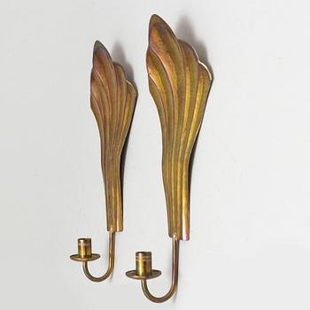 Four brass wall sconces  and one brass plate by Lars Homström, Arvika, second half of the 20th century.