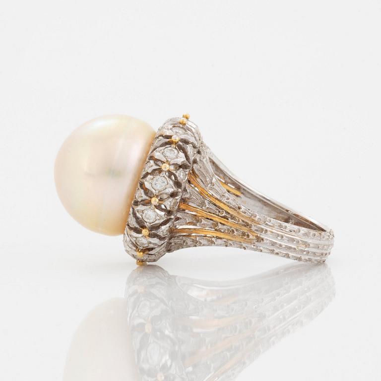 An 18K gold ring set with a cultured pearl and round brilliant-cut diamonds.