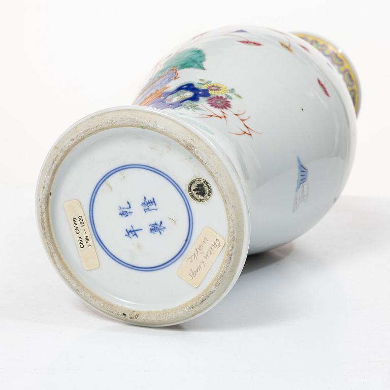 A slender famille rose 'flowers and antiques' vase, late Qing dynasty/early 20th century.