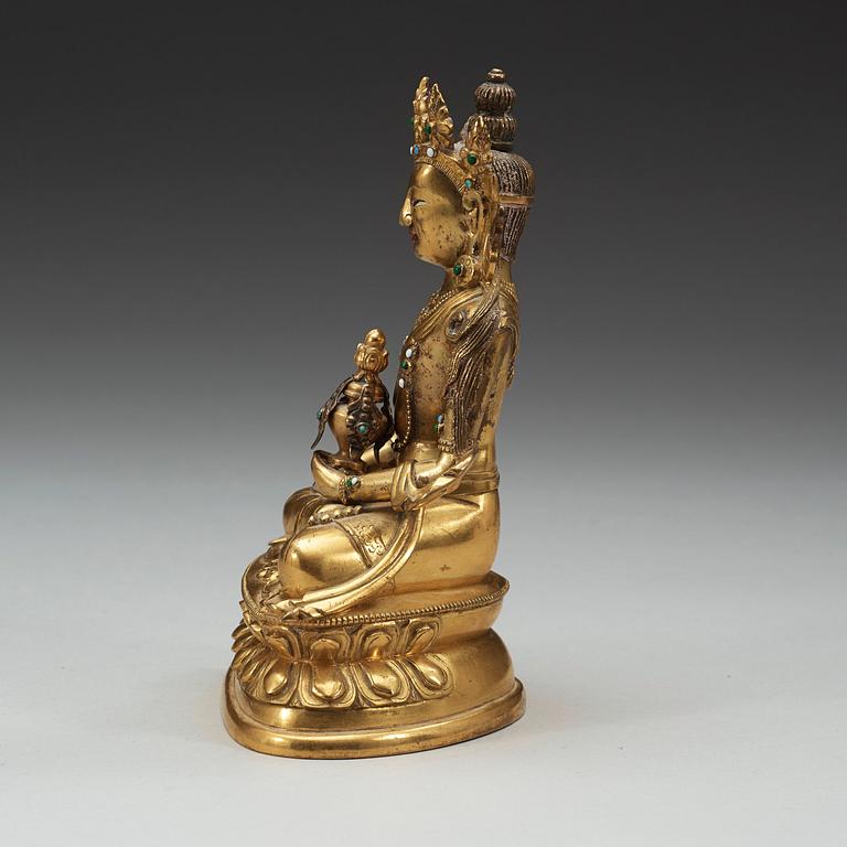 A stone inlayed gilt bronze figure of Amitayus, seated in meditation on a double lotus base, Qing dynasty, 18th Century.
