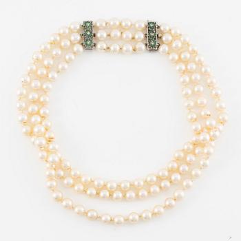 Collier tre rader odlade pärlor, lås 18K guld med vita stenar och smaragder.