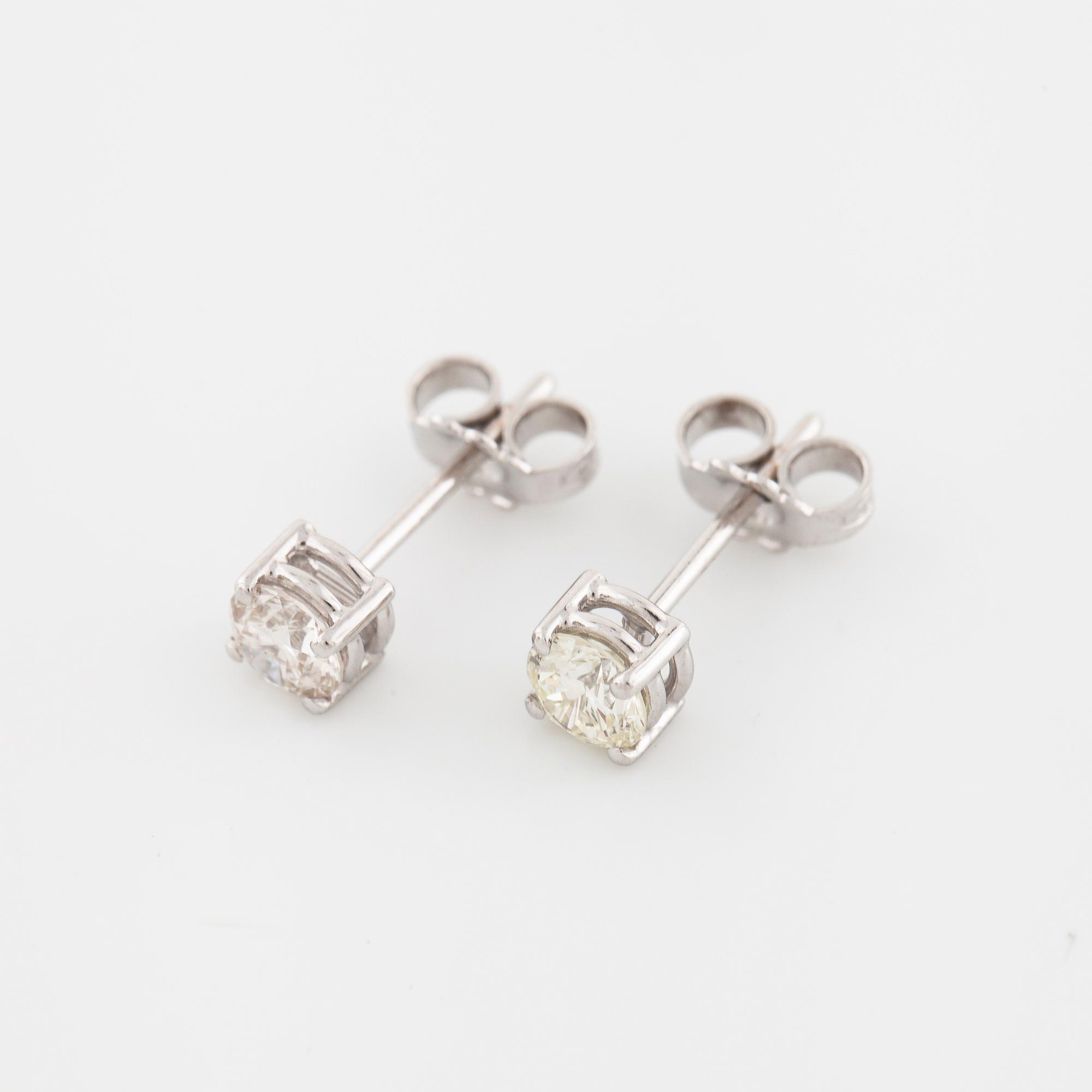 A pair of brilliant cut diamond earrings.