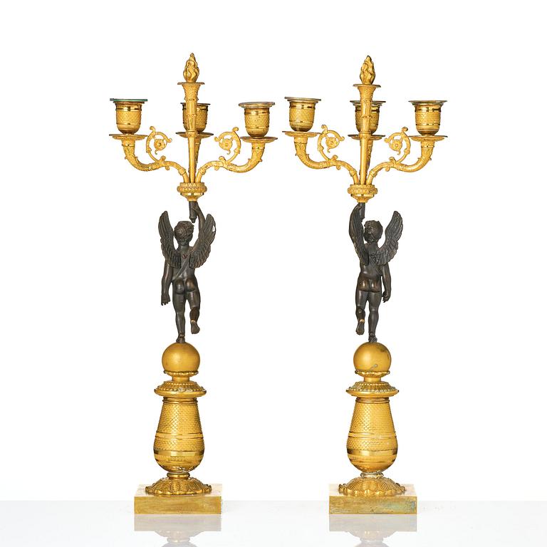 A pair of Empire three light ormolu and patinated bronze candelabra.