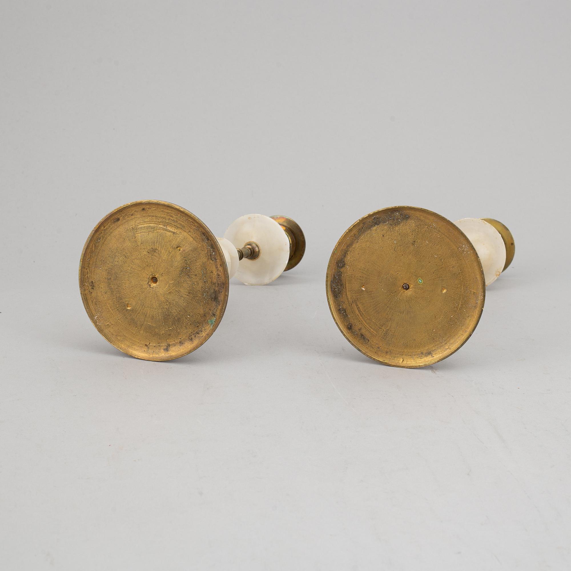 An alabaster mantle clock and pair of candlesticks, circa 1900.