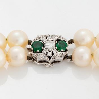 A two strand cultured pearl necklace clasp in 18K white gold set with a faceted emerald.