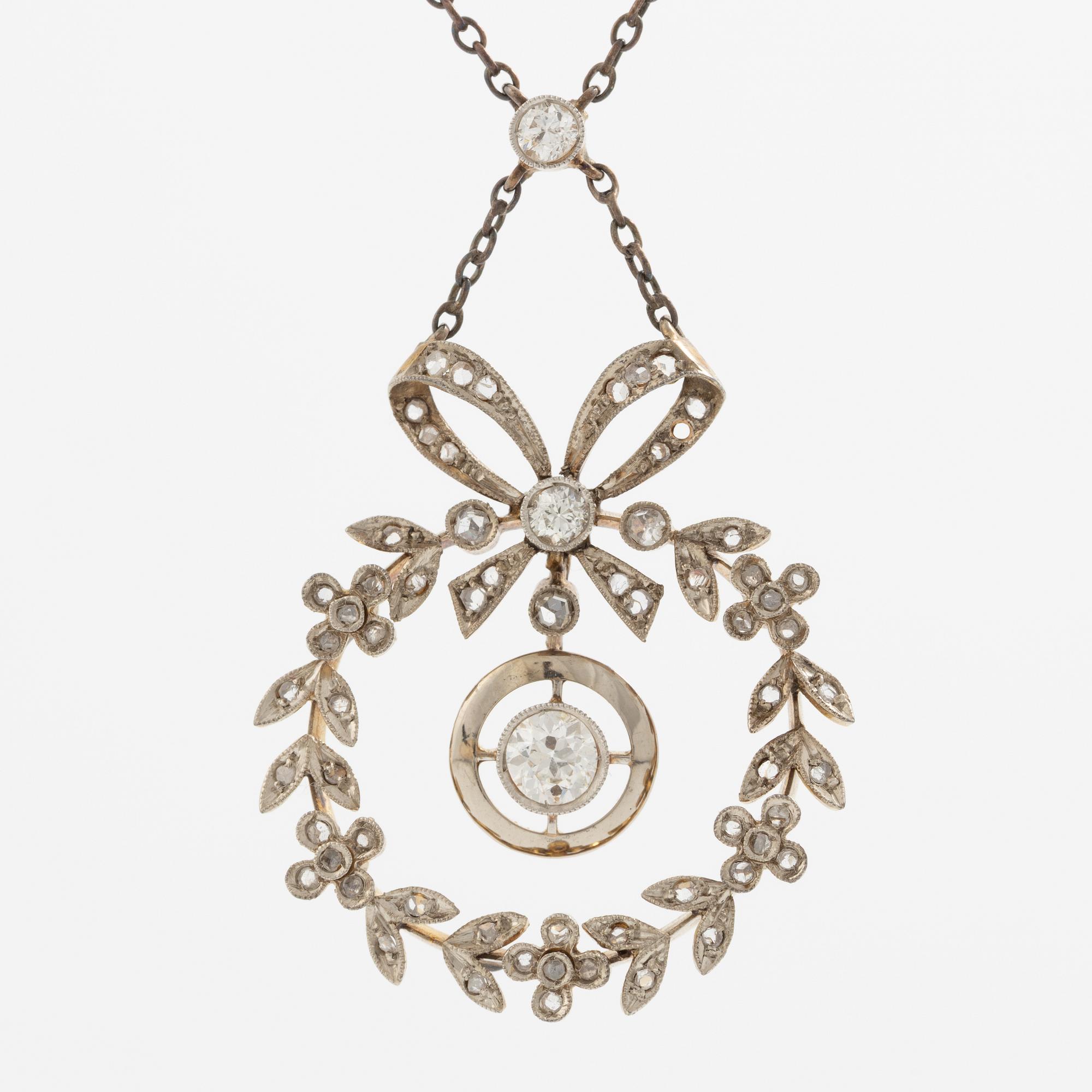 Hängsmycke 18K guld och silver i form av rosettkrans med gammal-och rosenslipade diamanter, omkring sekelskiftet 1900.