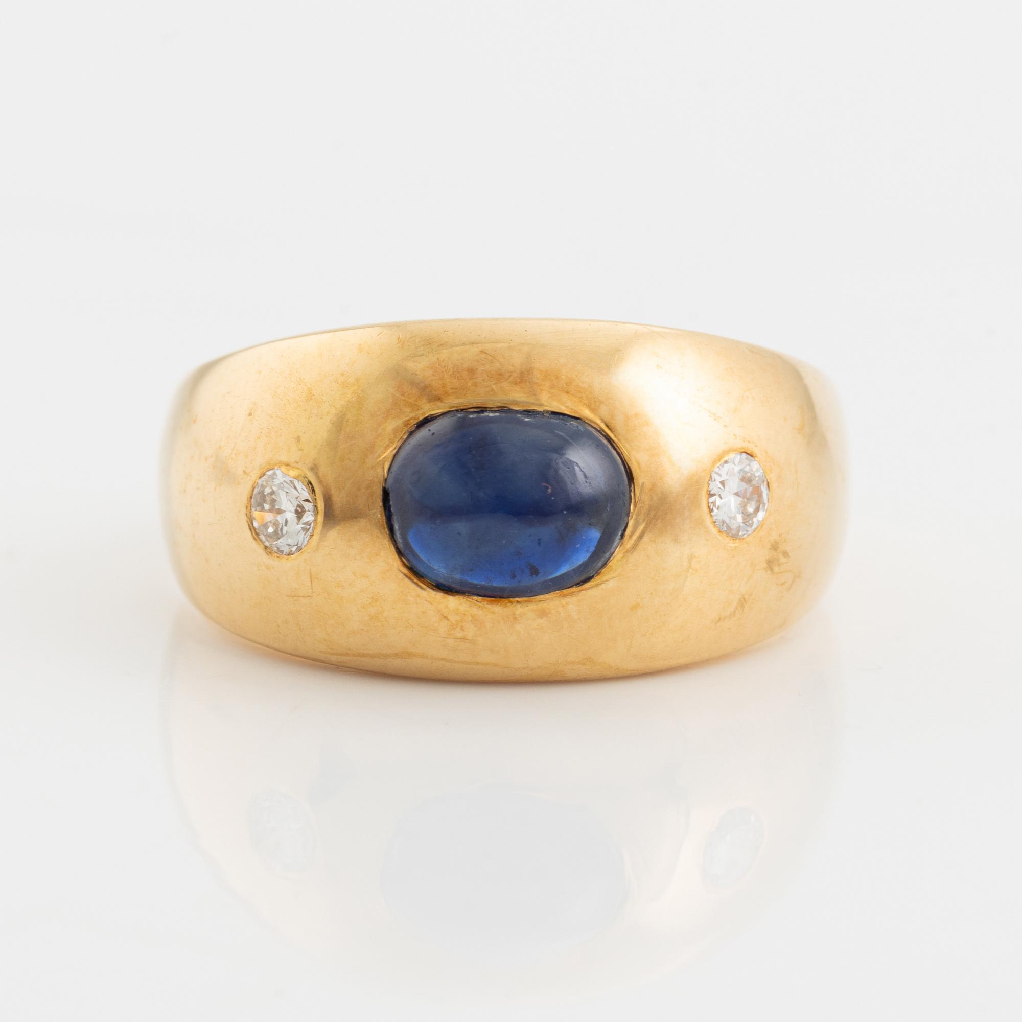 Ring 18K guld med en cabochonslipad safir och runda briljantslipade diamanter.