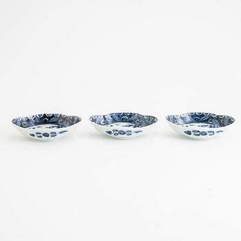 A set of three Japanese imari bowls and a Japanese blue and white servingdish with three boatshaped dishes, 19th century.