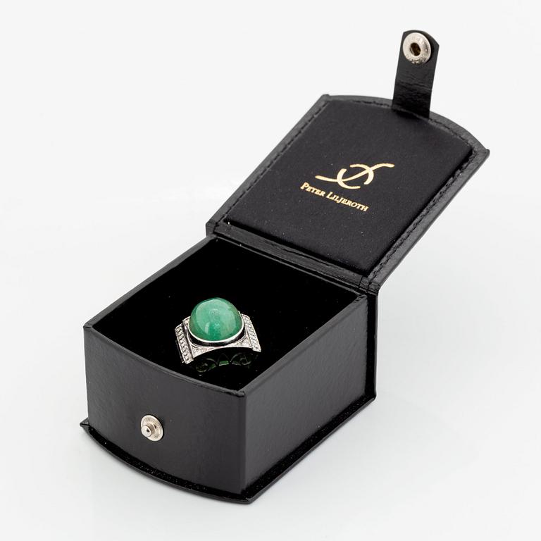 An 18K white gold ring set with a cabochon-cut emerald and round- and eight-cut diamonds.