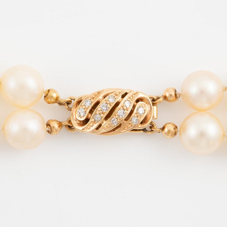 Necklace of two strands of cultured pearls, clasp with 18K gold lock set with eight-cut diamonds.