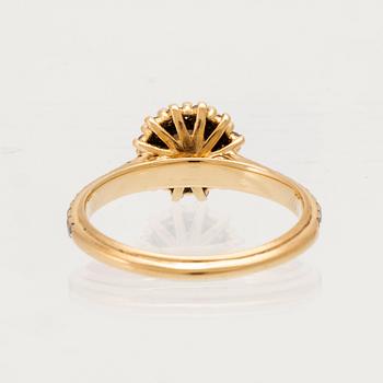 An 18K gold ring set with round brilliant-cut diamonds.