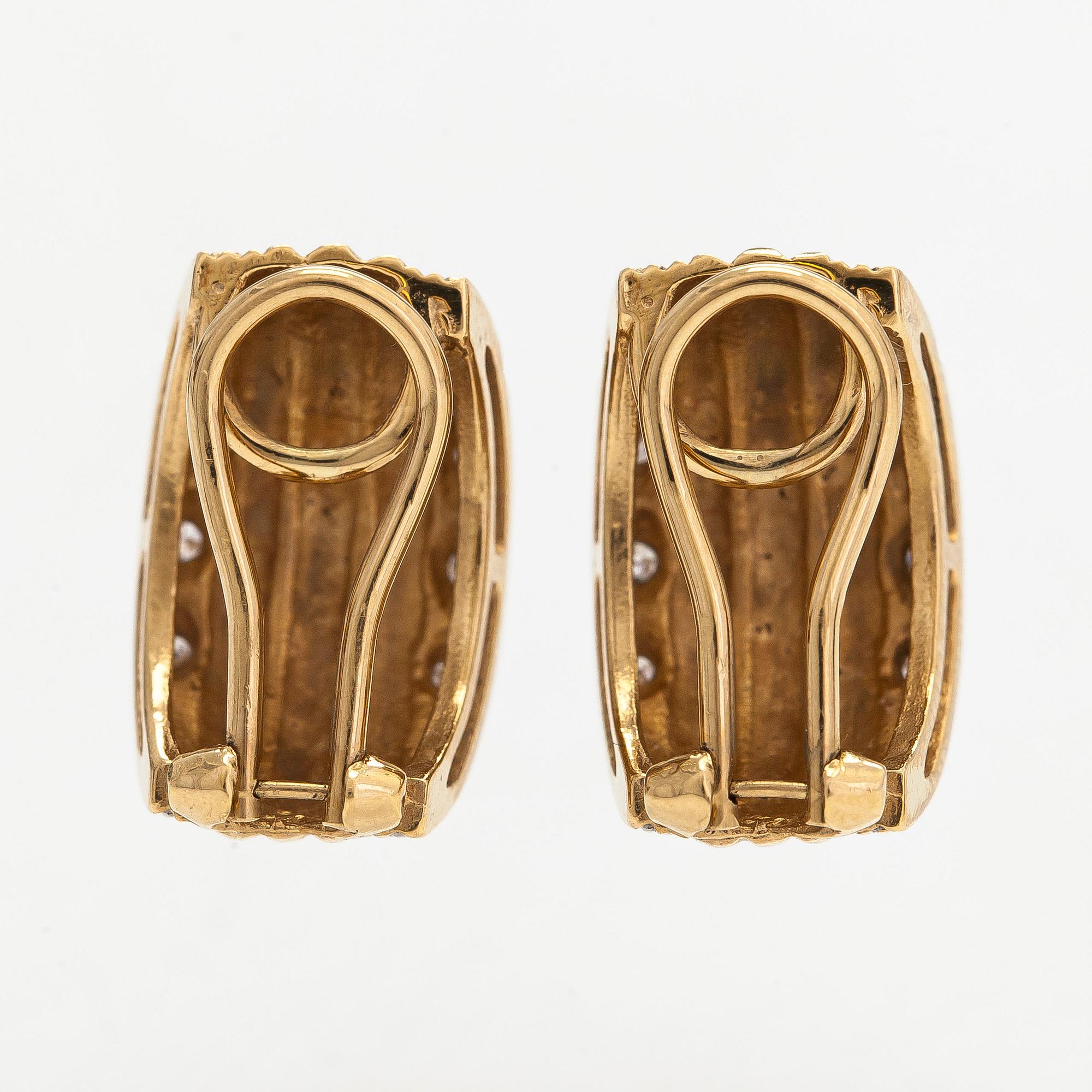 A pair of 18K gold earrings set with small diamonds.