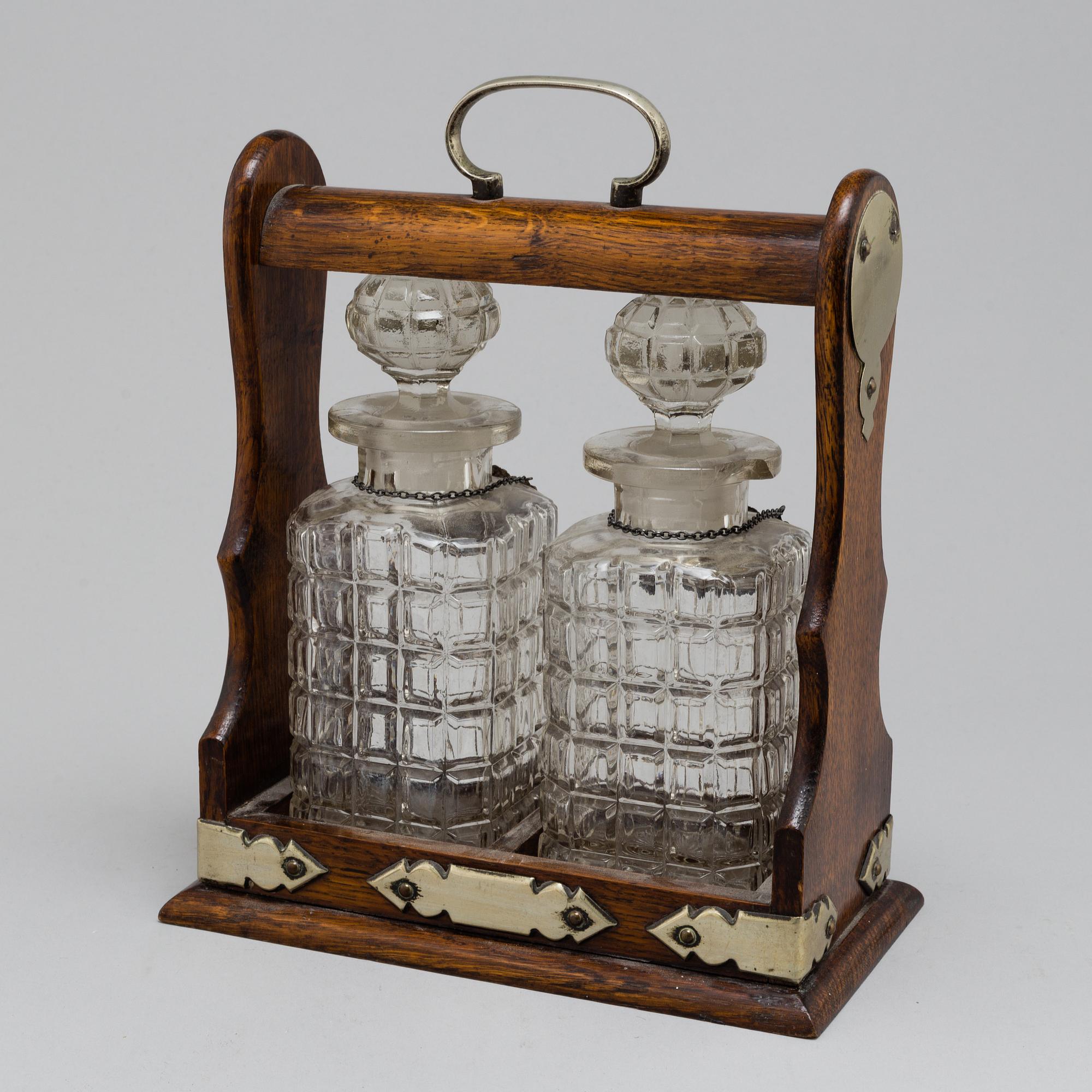 An oak, silver, silverplated and glass tantalus with lock. Second half of the 20th century.