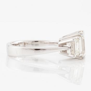 An 18K white gold ring set with three emerald-cut diamonds.