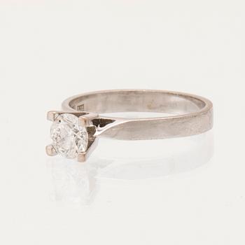 An 18K white gold solitaire ring set with a round brilliant-cut diamond.