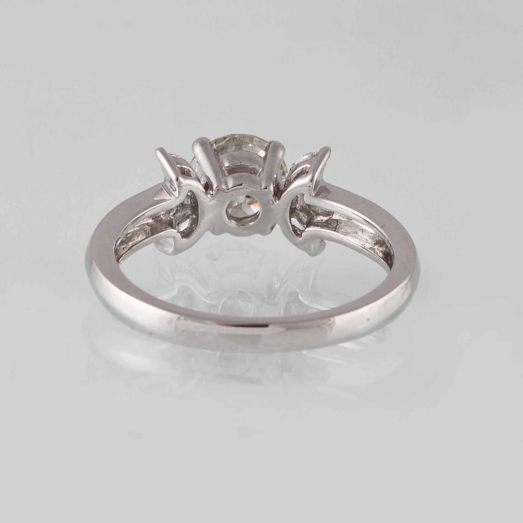 RING, 18K vitguld med briljantslipad diamant ca 1.11 ct samt 6 navetteslipade diamanter 0.26 ct. Vikt 4,2 gram.