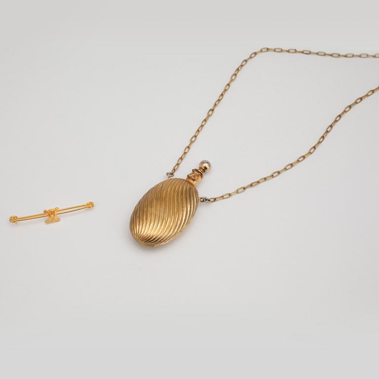 CÉLINE, a gold colored necklace with pendant as a perfume bottle and brooche.