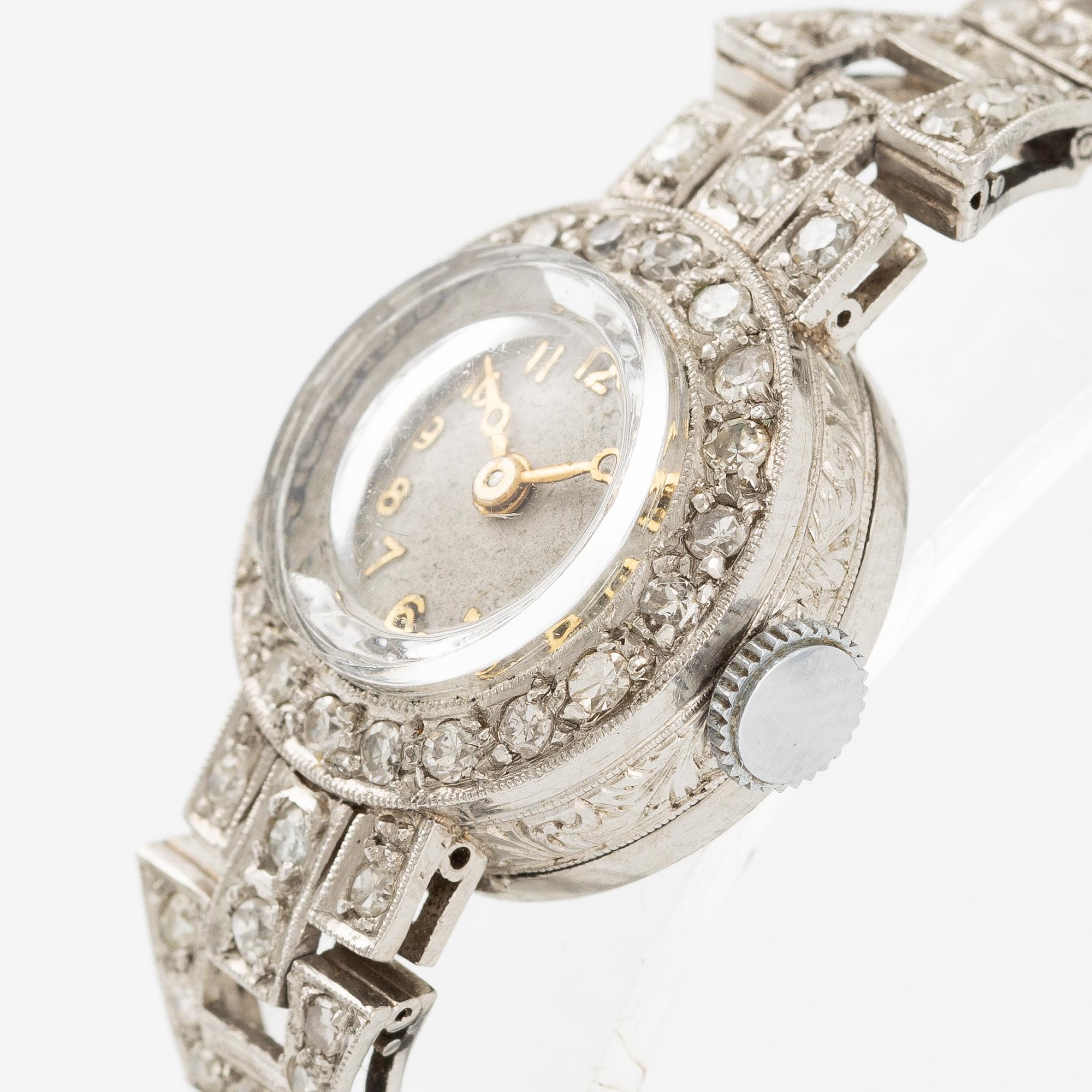 Damarmbandsur, platina med åttkantslipade diamanter, med textilrem.