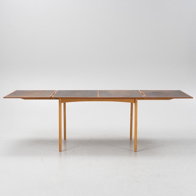 A 1960's teak and rosewood veneered dining table.