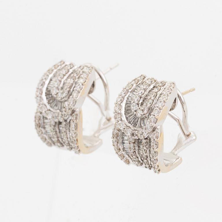 A pair of 18K gold earrings set with round brilliant- and baguette-cut diamonds.