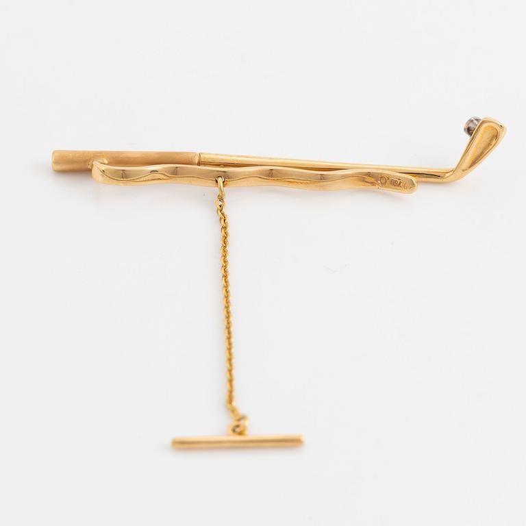 Slipsnål, 18K guld med briljantslipad diamant, i form av en golfklubba.