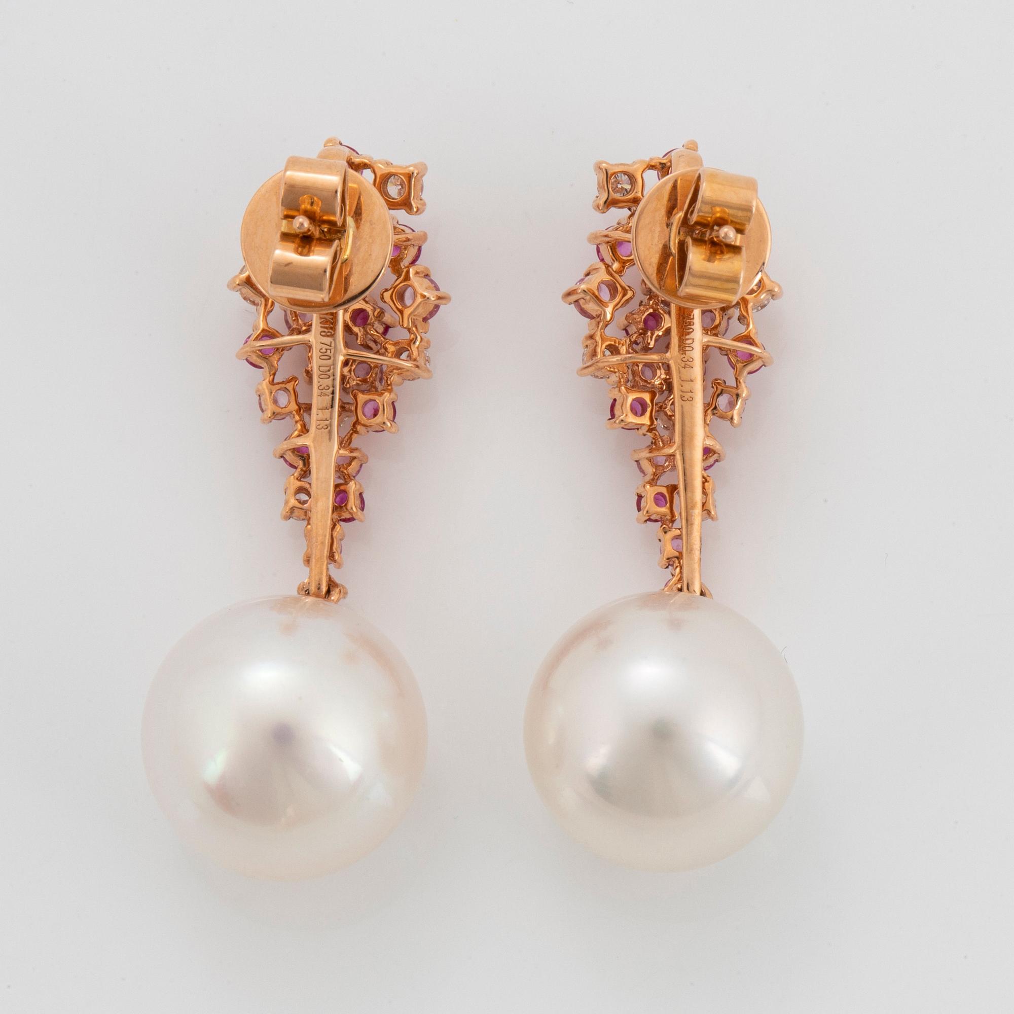 Ett par örhängen med odlade Söderhavspärlor samt runda briljantslipade diamanter och rosa safirer.